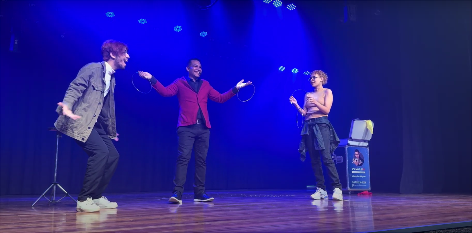 Três artistas no palco.